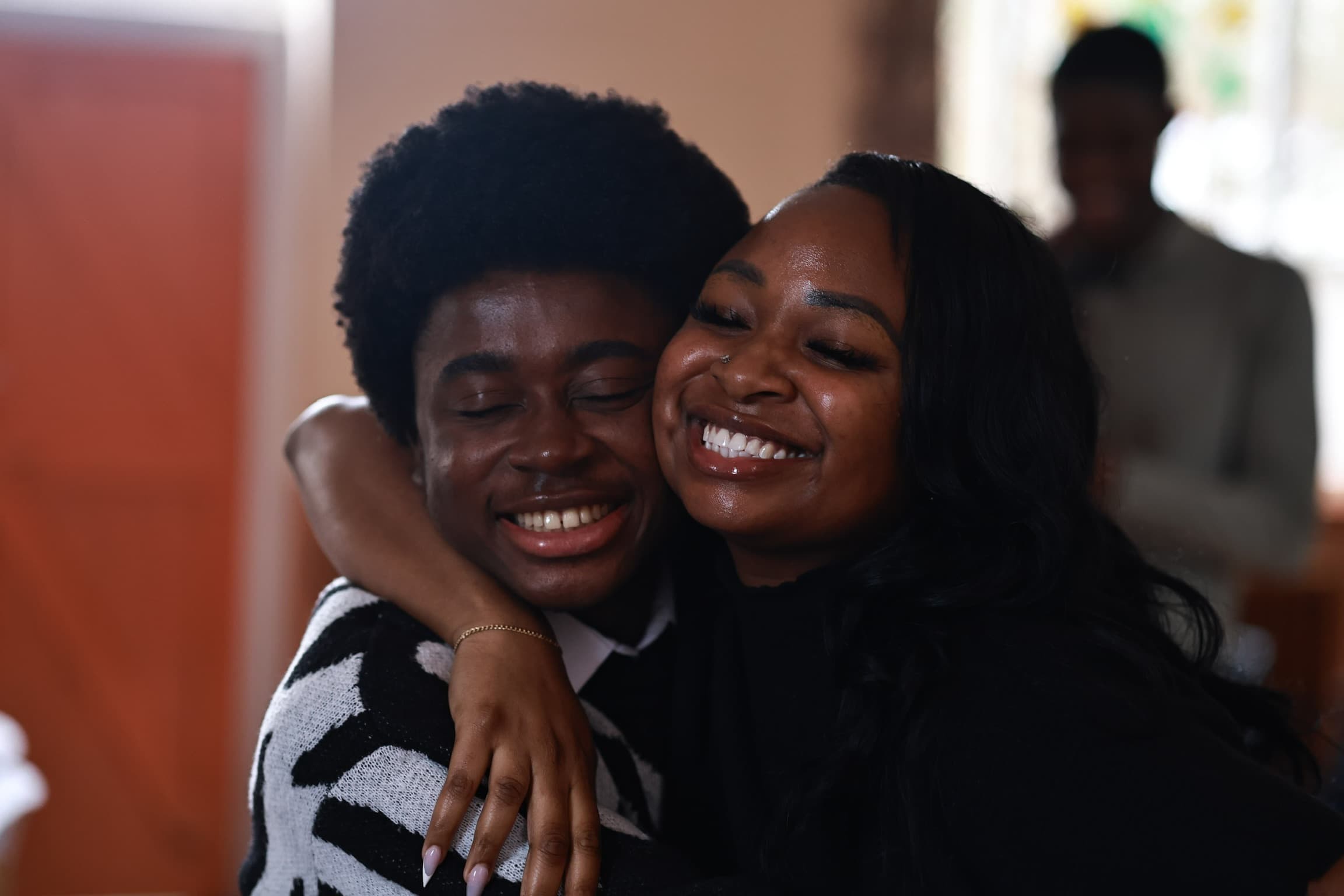 Two members of the church family embracing after a service