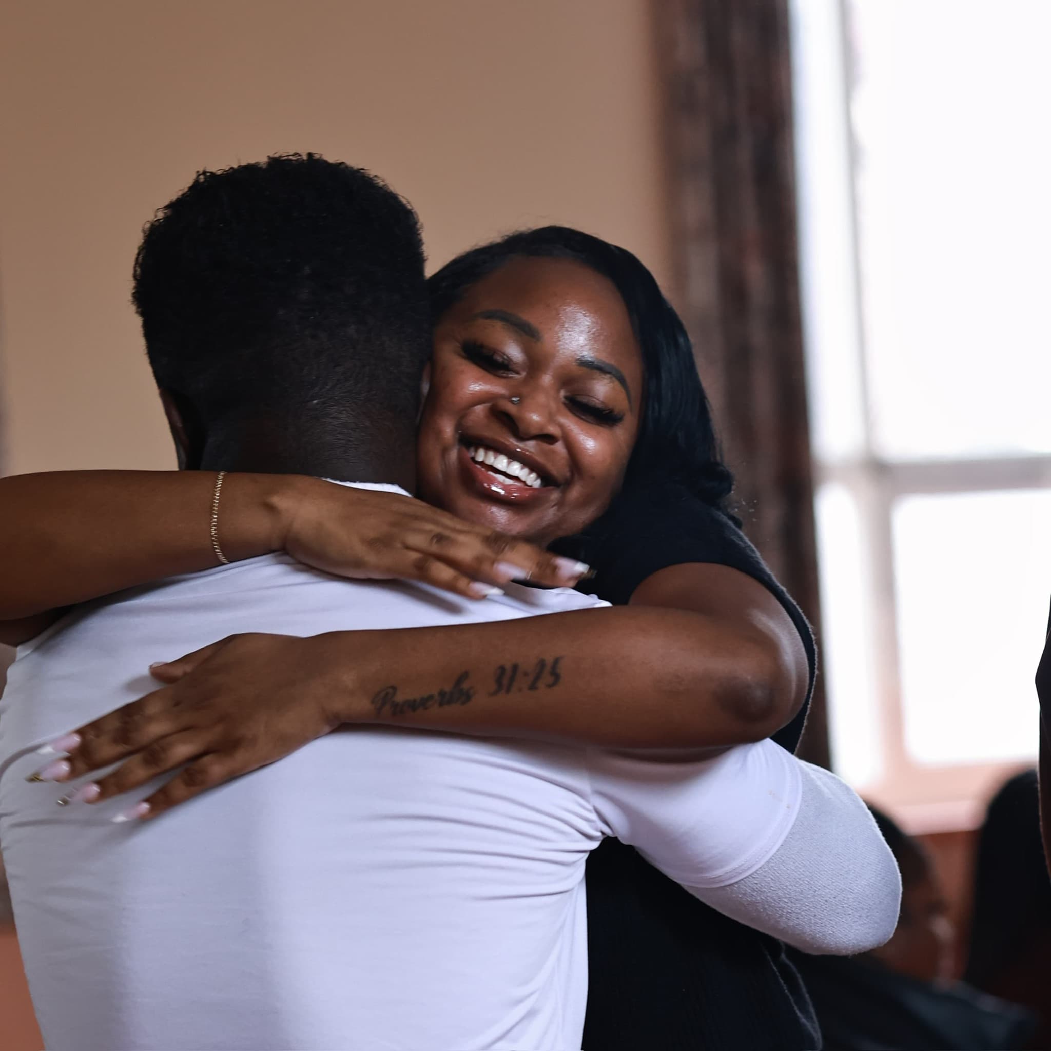 Two members of the church family embracing